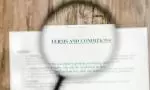Magnifying glass over a Terms and Conditions document image